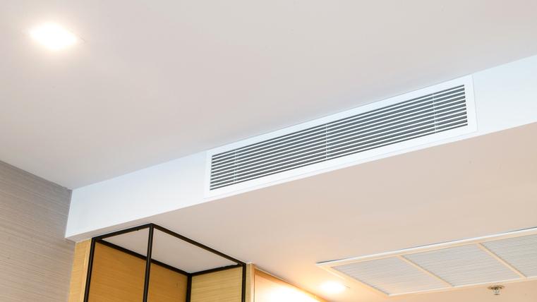 Decke mit integrierten länglichen Lüftungsgittern und Beleuchtung.